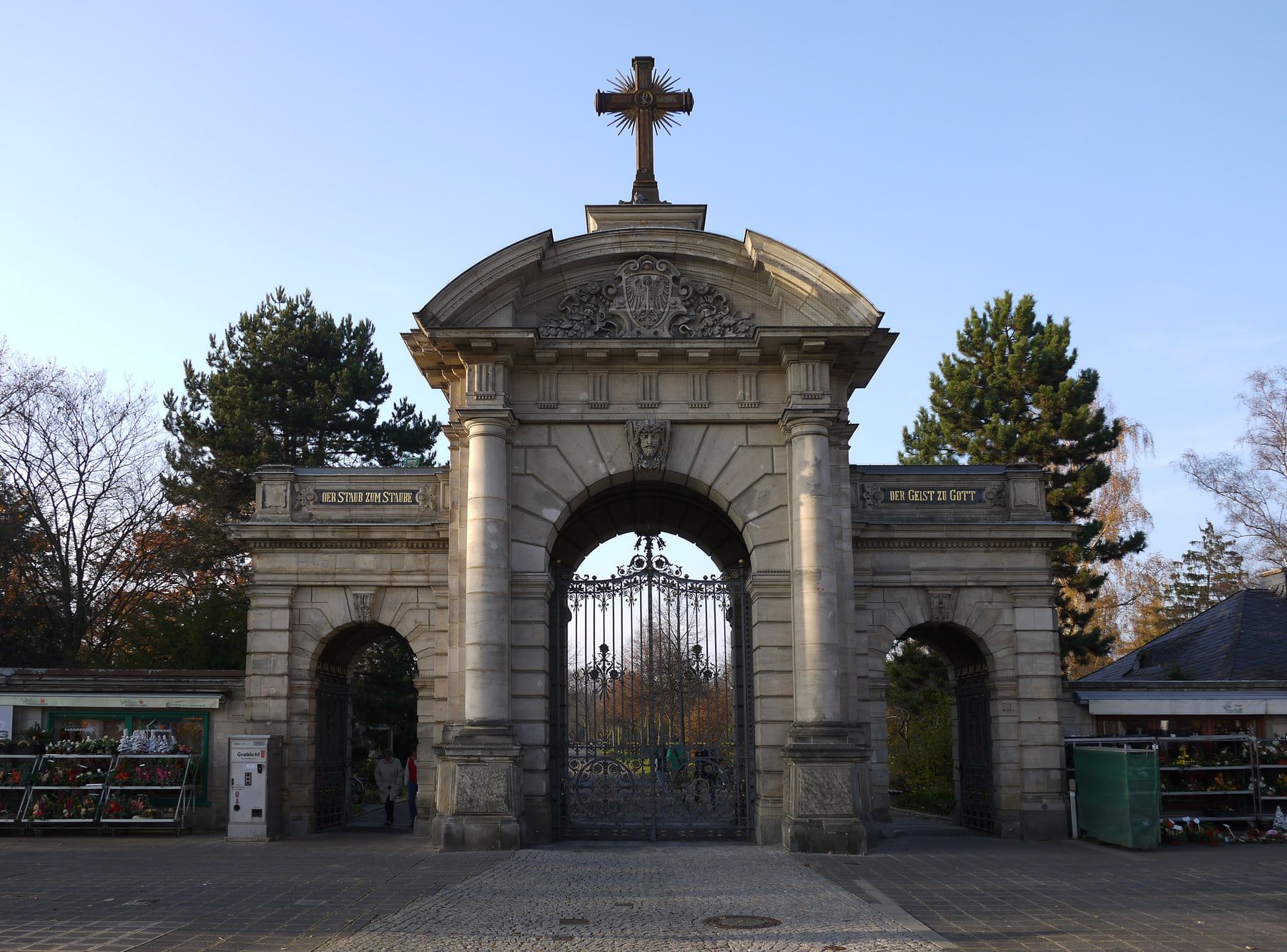 Monumentales steinernes Hauptportal mit Rundbogen, Kreuz und schmiedeeisernem Tor auf Westfriedhof Nürnberg